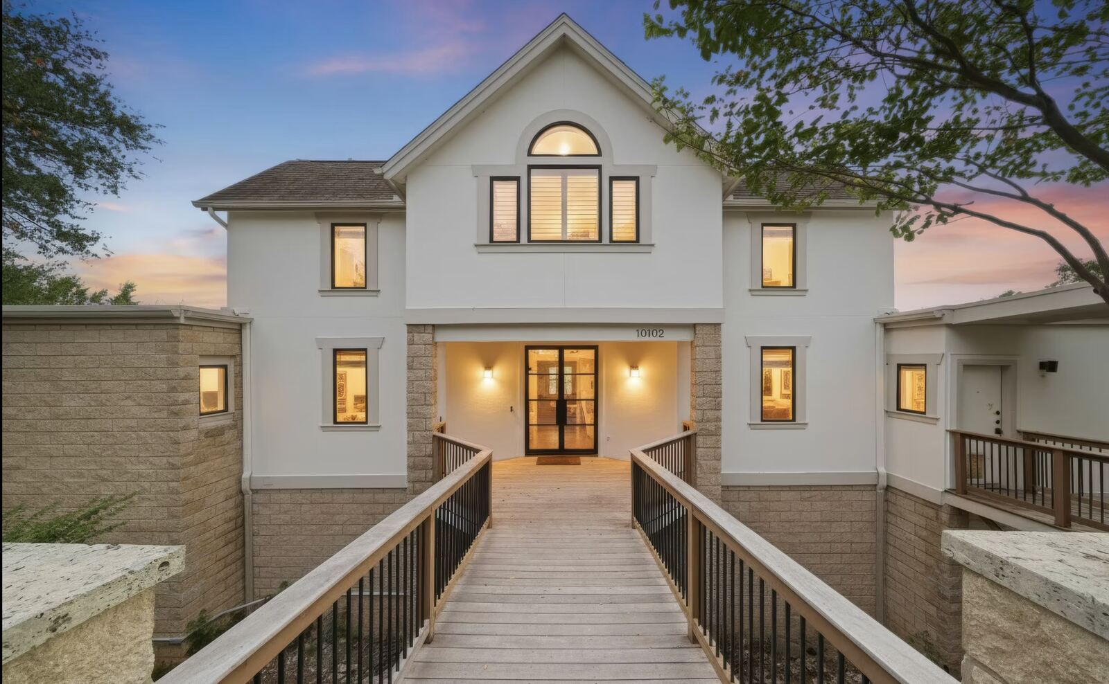 Twilight exterior with a bridge walkway to the front door