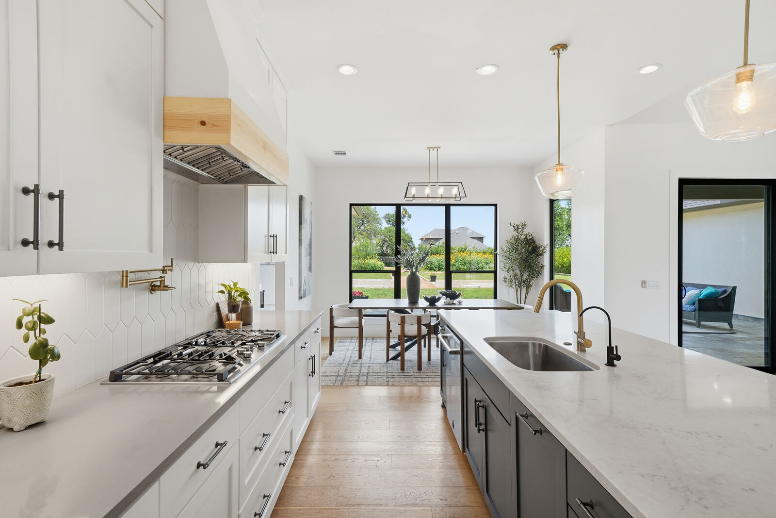 Modern kitchen with island, brass fixtures and view to the yard